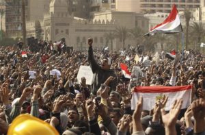 Opposition supporters gesture as they wave the national flags in Tahrir Square in Cairo